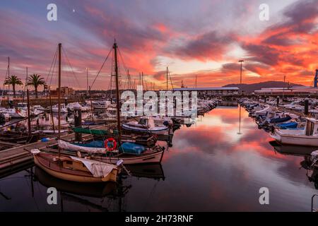 Ferrol, Spanien. 9. November 2021. Dramatischer Sonnenuntergang über dem alten Hafen von Ferrol. Kleine Angel- und Freizeitboote, die an Docks festgemacht sind. Galicien, Spanien Stockfoto