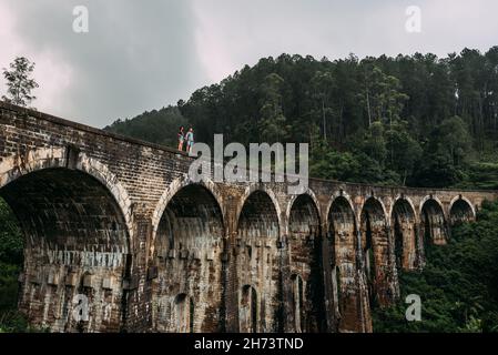 Liebevolles Paar am Rande der Brücke. Kerl und Mädchen, die durch Asien reisen. Das Paar reist nach Sri Lanka. Mann und Frau an einem ungewöhnlichen Ort. Neun- Stockfoto