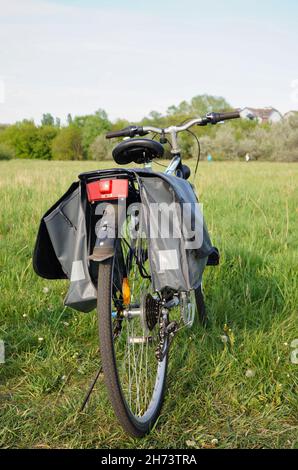 POSEN, POLEN - 09. Mai 2015: Nahaufnahme eines Fahrrads mit Einkaufstasche auf grünem Gras, Posen, Polen Stockfoto