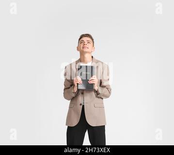 Teenager-Junge mit Bibel auf weißem Hintergrund Stockfoto