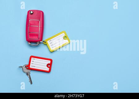 Schlüssel mit Plastikanhänger auf blauem Hintergrund Stockfoto