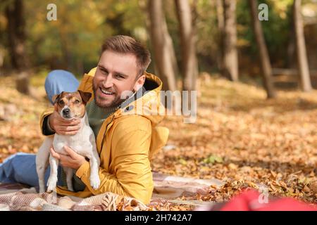 Schöner Mann mit witzigem Jack Russel Terrier im Park am Herbsttag Stockfoto