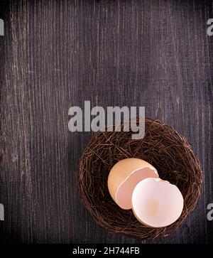 broun zerbrochene Eierschalen im Nest auf Holzoberfläche Stockfoto