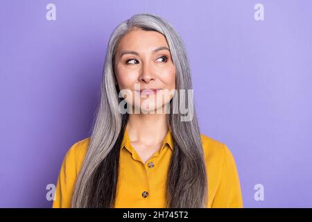 Porträt von attraktiven neugierigen Frau, die beiseite denkende Kopie Raum isoliert über hellen violett lila Farbe Hintergrund Stockfoto