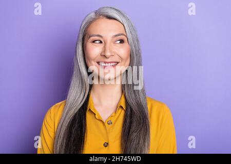 Portrait von attraktiven fröhlichen Frau suchen beiseite kopieren Raum isoliert über hellen violett lila Farbe Hintergrund Stockfoto