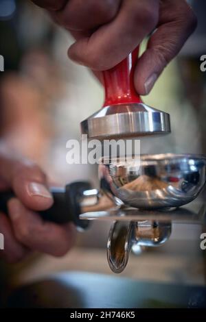 Nahaufnahme der Hände des Barkeepers, der Zubehör für die Zubereitung eines aromatischen und duftenden Espresso verwendet. Kaffee, Getränke, Bar Stockfoto