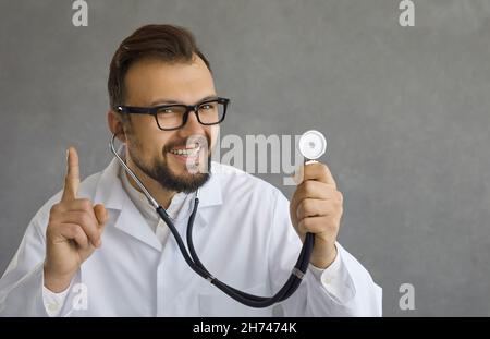 Nahaufnahme eines lächelnden männlichen Arztes mit einem schlauen Ausdruck, der zeigt, dass er eine Idee für eine Diagnose hat. Stockfoto