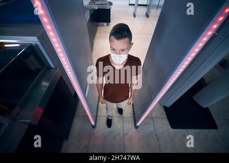 Sicherheitskontrolle am Flughafen. Passagiere, die durch das Tor des Metalldetektors fahren. Stockfoto