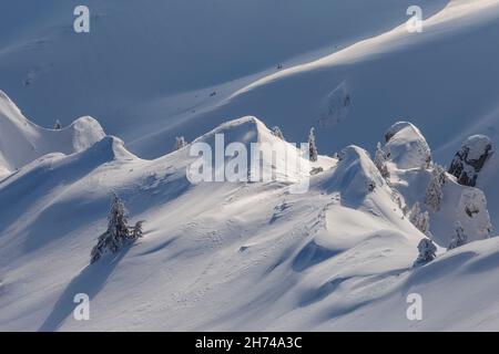 Blick auf schneebedeckten Berggebiet in schönem Licht mit Schatten und Sonne, Karpaten. Stockfoto