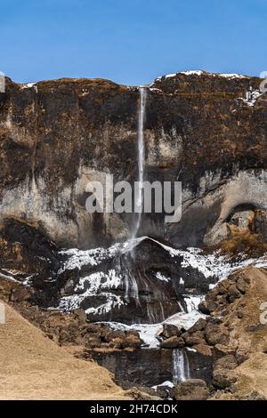 Foto eines isländischen Wasserfalls in Island mit Regenbogen Stockfoto