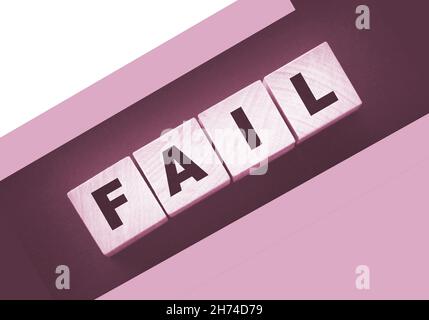 FAIL Word-Text in Holzwürfelblöcken auf schwarzem Hintergrund geschrieben. Krisenkonzept Stockfoto