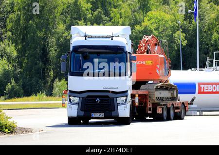 White Renault Trucks T schleppt Hitachi Zaxis 225 US-Raupenbagger auf Falldeckenauflieger und verlässt die Tankstelle. Forssa, Finnland. 31. Juli 2020. Stockfoto