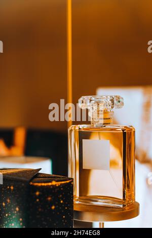 Transparente Flasche imitierte Parfüm vor goldenem Hintergrund. Lux-Flasche auf einem Ständer. Design Template für luxuriöse Parfümerie. Сopy Raum Stockfoto