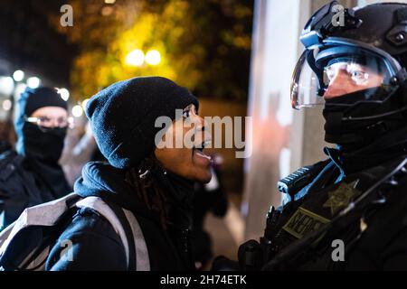 Eine Frau konfrontiert einen Polizisten am Südeingang des Justizzentrums während eines Protestes, um das Urteil im Kyle-Rittenhouse-Prozess zu verklagen. Portland, Oregon, USA, 19th. November 2021 (Mathieu Lewis-Rolland/SIPA USA) Stockfoto