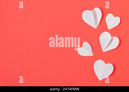 Valentinstag Hintergrund mit Papierherzen auf rotem Hintergrund mit Kopierplatz, flach liegend Stockfoto