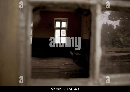 Verlassenes Haus durch eine kaputte Glastür Stockfoto