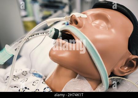 Patientendummy mit Intubation im Krankenhausbett auf der Intensivstation eines Krankenhauses. Stockfoto