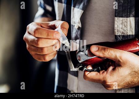 Barber, der Öl in seine Haarschneidemaschine gegeben hat Stockfoto