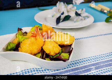 Frittierte panierte Garnelen mit grünem Salat und Tischset. Stockfoto