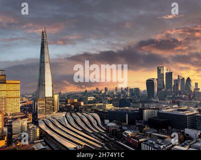 Luftaufnahme des Bahnhofs London Bridge, The Shard mit Blick auf die Stadt und das Finanzviertel mit dramatischem Sonnenaufgang und stimmtem Himmel Stockfoto