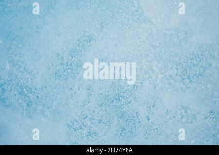Textur der Wintereisoberfläche. Blauer natürlicher Eishintergrund. Luftblasen im Eis Stockfoto