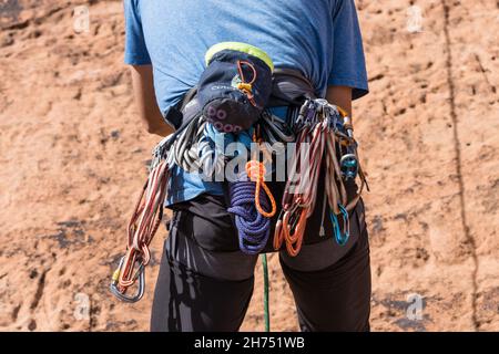 Kletterausrüstung am Klettergurt eines Kletterers an der Wall Street in der Nähe von Moab, Utah. Stockfoto