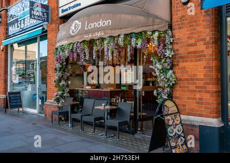 LONDON, Großbritannien - 11. NOVEMBER 2021: Das Bye Bye London Restaurant an der geschäftigen King's Road in Chelsea bietet eine Vielzahl von vorwiegend biologischen Gerichten aus dem Nahen Osten Stockfoto