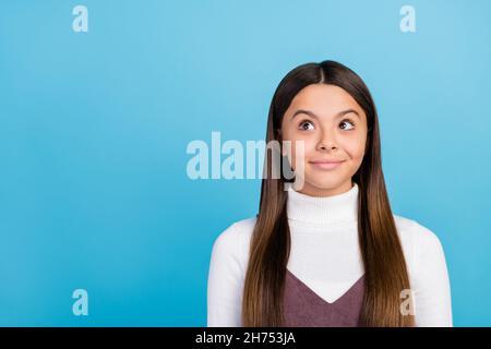 Foto von jungen hübschen kleinen Mädchen fragte Blick leeren Raum nachdenklich isoliert über blauen Hintergrund Stockfoto