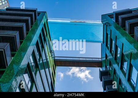 LONDON, Großbritannien - 11 2021. NOVEMBER: Blick nach oben auf den schwimmenden Sky Pool schwebte 115 Meter in der Luft zwischen dem prominenten Gebäude der Embassy Gardens Stockfoto