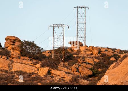 Blick am frühen Morgen auf alte Stromtürme, die trockene Berge in der Nähe des Santa Susana Pass State Historic Park im Los Angeles County, Kalifornien überqueren. Stockfoto