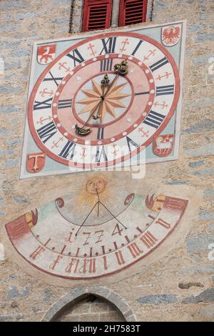 NATZ-SCHABS, ITALIEN - 13. OKTOBER 2019: Vor kurzem restaurierte Uhr und Sonnenuhr, die vor dem Glockenturm der Kirche der Stadt gemalt wurde. Stockfoto