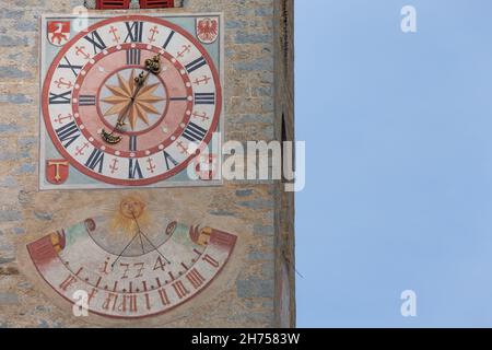 NATZ-SCHABS, ITALIEN - 13. OKTOBER 2019: Vor kurzem restaurierte Uhr und Sonnenuhr, die vor dem Glockenturm der Kirche der Stadt gemalt wurde. Stockfoto