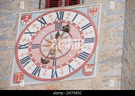 NATZ-SCHABS, ITALIEN - 13. OKTOBER 2019: Vor kurzem restaurierte Uhr und Sonnenuhr, die vor dem Glockenturm der Kirche der Stadt gemalt wurde. Stockfoto