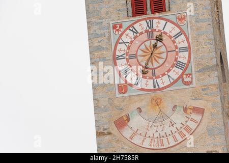 NATZ-SCHABS, ITALIEN - 13. OKTOBER 2019: Vor kurzem restaurierte Uhr und Sonnenuhr, die vor dem Glockenturm der Kirche der Stadt gemalt wurde. Stockfoto