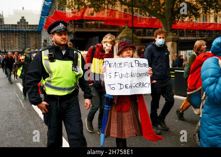 London, Großbritannien. 20th. November 2021. Ein Aktivist hält während der Demonstration ein Plakat. Die Aktivisten der Beleidigung Großbritanniens marschierten in Solidarität mit den neun Aktivisten, die wegen einer Verfügung inhaftiert wurden, indem sie am 8th. Oktober an der Blockade an der Kreuzung 25 der M25 teilnahmen, um die Regierung aufzufordern, die Isolierung von sozialem Wohnungsbau bis 2025 und aller Häuser zu finanzieren In Großbritannien bis 2030. Der marsch begann am Königlichen Gerichtshof um 12pm Uhr und Aktivisten sind bereit, zivilen Ungehorsam in der Stadt zu verursachen. Kredit: SOPA Images Limited/Alamy Live Nachrichten Stockfoto