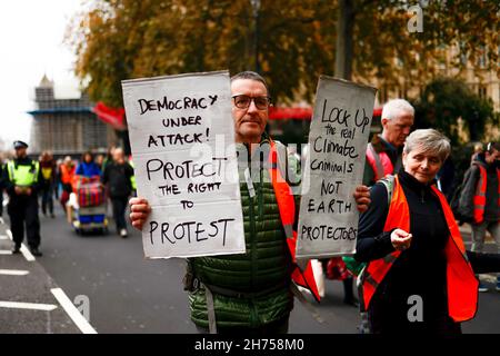 London, Großbritannien. 20th. November 2021. Ein Aktivist hält Plakate während der Demonstration. Die Aktivisten der Beleidigung Großbritanniens marschierten in Solidarität mit den neun Aktivisten, die wegen einer Verfügung inhaftiert wurden, indem sie am 8th. Oktober an der Blockade an der Kreuzung 25 der M25 teilnahmen, um die Regierung aufzufordern, die Isolierung von sozialem Wohnungsbau bis 2025 und aller Häuser zu finanzieren In Großbritannien bis 2030. Der marsch begann am Königlichen Gerichtshof um 12pm Uhr und Aktivisten sind bereit, zivilen Ungehorsam in der Stadt zu verursachen. (Foto von Hesther Ng/SOPA Images/Sipa USA) Quelle: SIPA USA/Alamy Live News Stockfoto