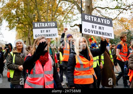 London, Großbritannien. 20th. November 2021. Aktivisten halten während der Demonstration Plakate. Die Aktivisten der Beleidigung Großbritanniens marschierten in Solidarität mit den neun Aktivisten, die wegen einer Verfügung inhaftiert wurden, indem sie am 8th. Oktober an der Blockade an der Kreuzung 25 der M25 teilnahmen, um die Regierung aufzufordern, die Isolierung von sozialem Wohnungsbau bis 2025 und aller Häuser zu finanzieren In Großbritannien bis 2030. Der marsch begann am Königlichen Gerichtshof um 12pm Uhr und Aktivisten sind bereit, zivilen Ungehorsam in der Stadt zu verursachen. (Foto von Hesther Ng/SOPA Images/Sipa USA) Quelle: SIPA USA/Alamy Live News Stockfoto