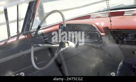 Innenarchitektur des klassischen amerikanischen Autos. Aktion. Ansicht eines klassisch roten Innenraums und eines Armaturenbretts in neuwertigem Zustand. Stockfoto