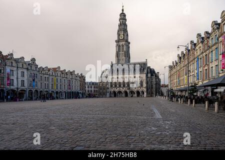 Arras, Frankreich - 4. November 2021: Marktplatz von Arras, Frankreich. Der Belfried von Arras, das zum UNESCO-Weltkulturerbe gehört, steht vor einem dunkelgrauen Himmel Stockfoto