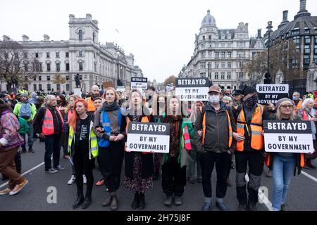 Demonstranten marschieren vor dem Parliament Square, während sie Plakate halten, auf denen steht, dass sie während der Demonstration von meiner Regierung verraten wurden.Beleidigung Großbritanniens ist eine zivile Widerstandskampagne, die die britische Regierung auffordert, ein nationales Programm zur Isolierung von Wohnheimen zu finanzieren. Einer der 9 Aktivisten, kollektiv als Highway 9 bekannt, darunter Ben Taylor, wurde in den letzten Monaten wegen einer Reihe von Protesten zu Gefängnis verurteilt. Die Gruppe protestierte, um mehr Maßnahmen der Boris-Regierung zur Bewältigung von Klimanotfällen zu fordern. Der marsch begann vor den königlichen Gerichtshöfen und ging zum Parlament. (Foto von Belin Stockfoto