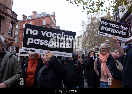 London, Großbritannien. 20th. November 2021. Demonstranten sahen während der Demonstration Plakate mit der Aufbringung von Impfpässen ohne Impfpass.von StandupX aufgerufen, versammelten sich Anti-Vaxer in London im Rahmen der weltweiten Kundgebung für die Bewegungsfreiheit. Die Gruppe protestiert gegen obligatorische COVID-Impfstoffe und die Implementierung von Impfstoffkennzeichnungen und Pässen. Kredit: SOPA Images Limited/Alamy Live Nachrichten Stockfoto