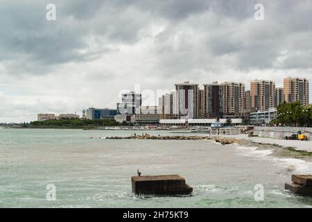 Novorossijsk, Russland, 13. August 2021: Panoramablick vom westlichen Pier auf den zentralen Strand und die Hochhäuser der modernen südlichen Stadt o Stockfoto