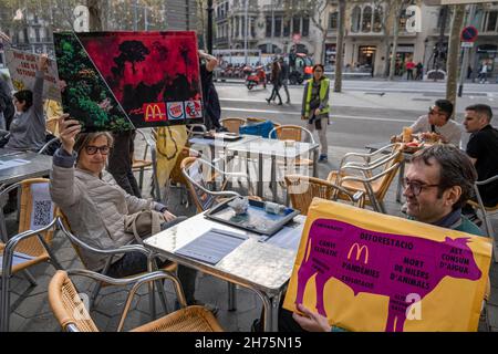 Barcelona, Spanien. 20th. November 2021. Aktivisten hielten während der Demonstration Plakate mit ihrer Meinung.Aktivisten der Tieraufstand besetzten eine Terrasse eines McDonalds-Establishments in Passeig de Gràcia in Barcelona, wo sie den Übergang zu einem gerechteren und nachhaltigeren Ernährungssystem forderten. (Foto von Paco Freire/SOPA Images/Sipa USA) Quelle: SIPA USA/Alamy Live News Stockfoto