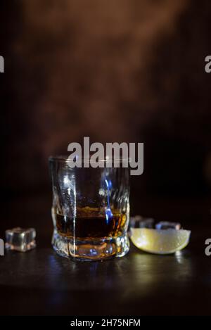 Trinken Sie Alkohol-Whiskey oder Rum in einem Glas mit Eis Stockfoto