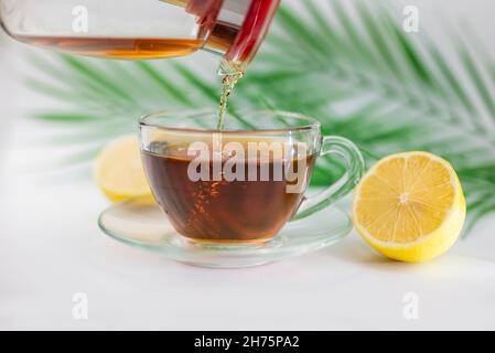 Heißer schwarzer Tee in einer Tasse mit Zitrone und Ingwer trinken Stockfoto