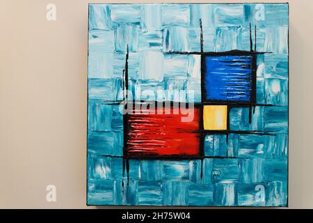 Abstrakte Acrylmalerei von türkisfarbenen Quadraten mit roten blauen und gelben Würfel auf quadratischem Leinwandrahmen Stockfoto