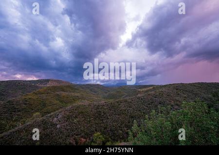 Faszinierende Aussicht auf bewaldete Berge unter dem wolkigen Himmel Stockfoto