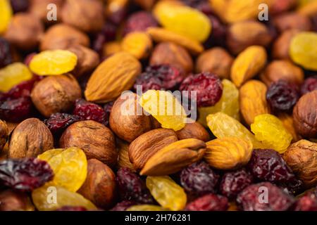 Mischung aus getrockneten Früchten. Gesunde Snacks. Mandeln, Rosinen, Haselnüsse, Preiselbeeren. Verschiedene Nüsse und getrocknete Beeren. Selektiver Fokus, Fokus auf der Vorderseite. H Stockfoto