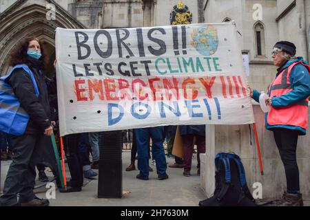 London, Großbritannien. 20th. November 2021. Während der Demonstration zur Beleidigung Großbritanniens halten Demonstranten vor den königlichen Gerichtshöfen ein Transparent mit der Aufforderung an Boris Johnson, gegen die Klimaklage zu handeln.Demonstranten marschierten durch London, um gegen die jüngste Inhaftierung von neun Aktivisten aus Großbritannien zu protestieren. Die Aktivisten fordern, dass die Regierung bis 2025 jeglichen sozialen Wohnungsbau isoliert und die Verantwortung dafür übernimmt, dass alle Häuser im Vereinigten Königreich bis 2030 energieeffizienter sind, als Teil der umfassenderen Ziele für den Klimawandel und die Dekarbonisierung. Kredit: SOPA Images Limited/Alamy Live Nachrichten Stockfoto