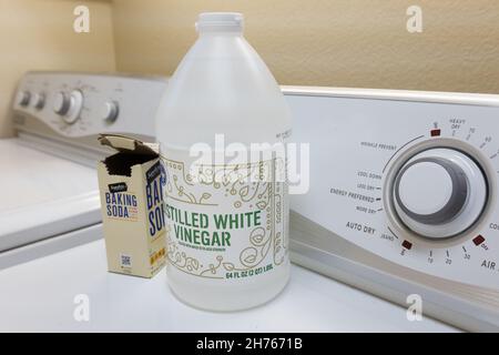 Weißer Essig und Backpulver in einer Waschküche, die zum Auffrischen muffiger Handtücher und anderer Wäsche verwendet wird. Stockfoto